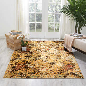 Living room scene with a Nourison Rhapsody Beige Gold rug, white bench, wood accent table, and natural light.