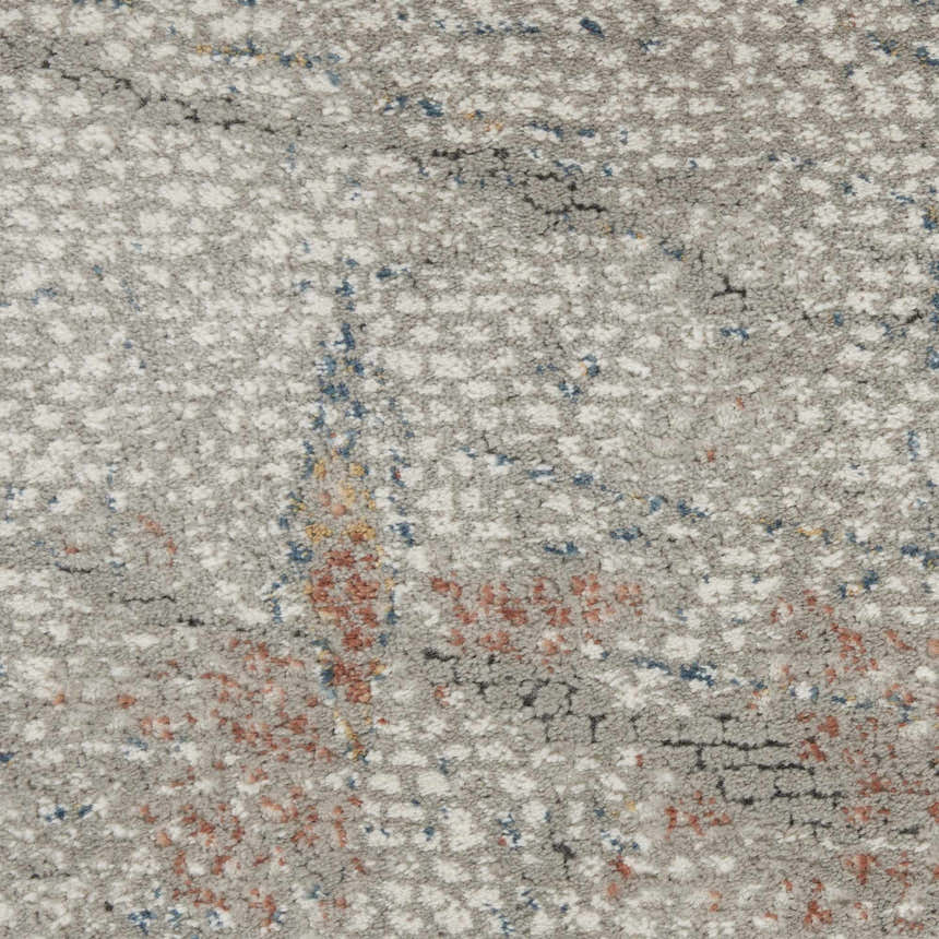 Close-up of Nourison Rustic Textures Light Grey Rust rug. Modern design with light gray, rust, and blue hues. Textured pattern.