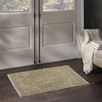Entryway with Nourison Heritage Vine Light Blue vintage rug, dark wood floors, and cream armchair with throw.