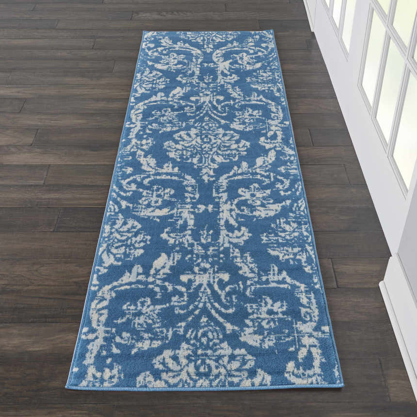 Hallway with a Nourison Jubilant Blue Vintage runner rug on dark wood floors, next to a white window.