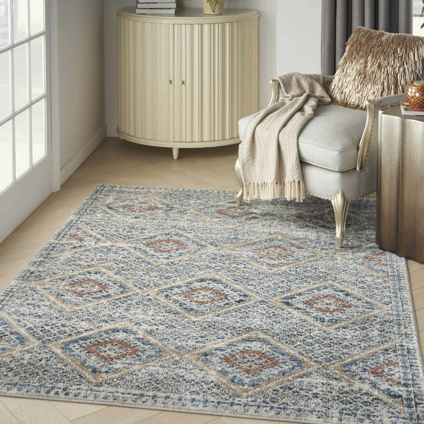 Living room scene with Nourison Quarry Blue Multicolor rug, accent chair, and cream-colored cabinet.
