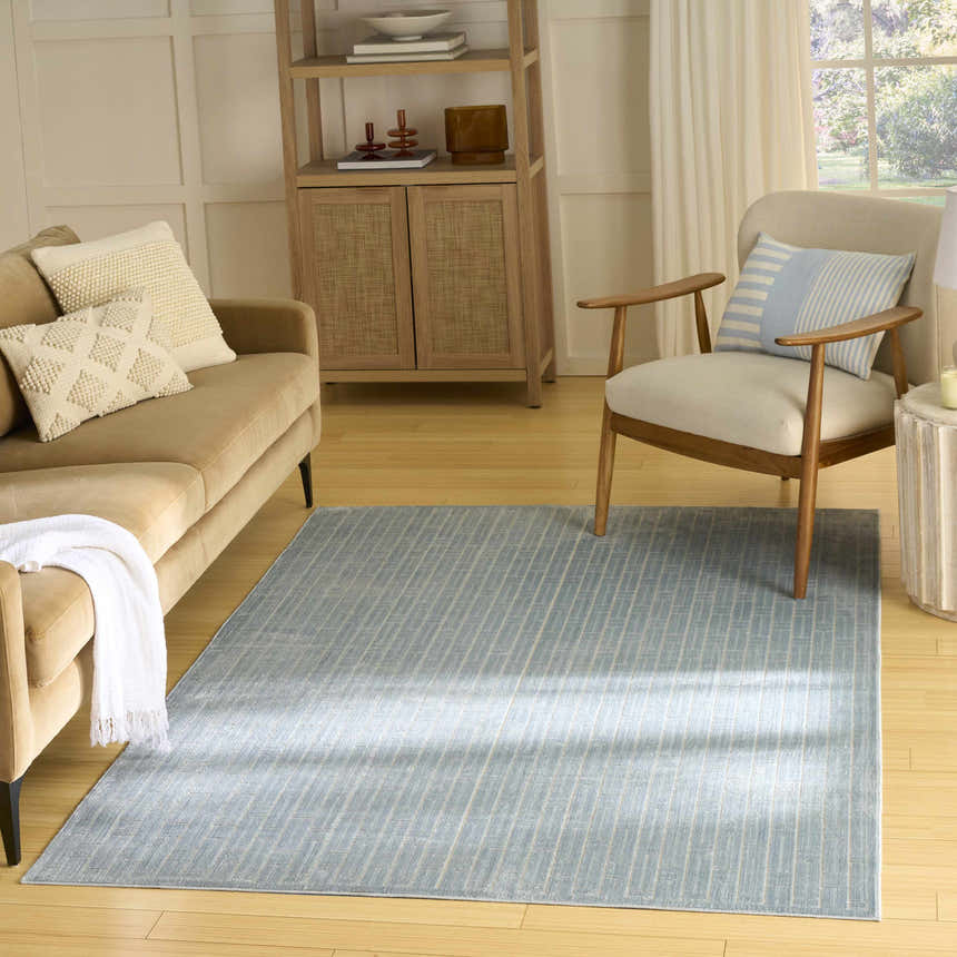 Living room scene with a Nourison Charm Blue Ivory rug, tan sofa, and mid-century modern decor.