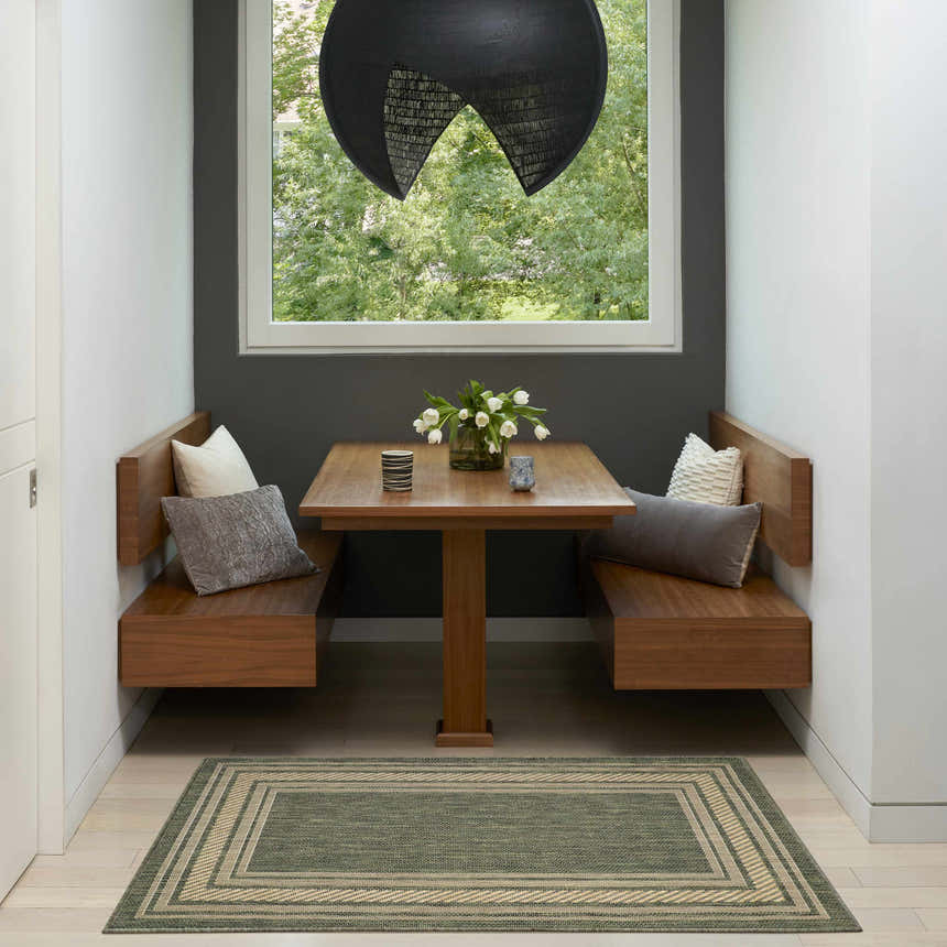 Modern dining nook with wood benches and a Nourison Horizon green area rug.