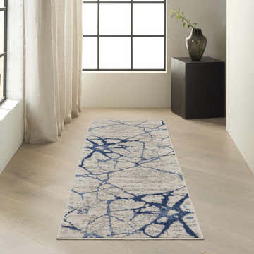 Modern hallway with Calvin Klein River Flow ivory and blue runner rug, wood floors, and natural light.