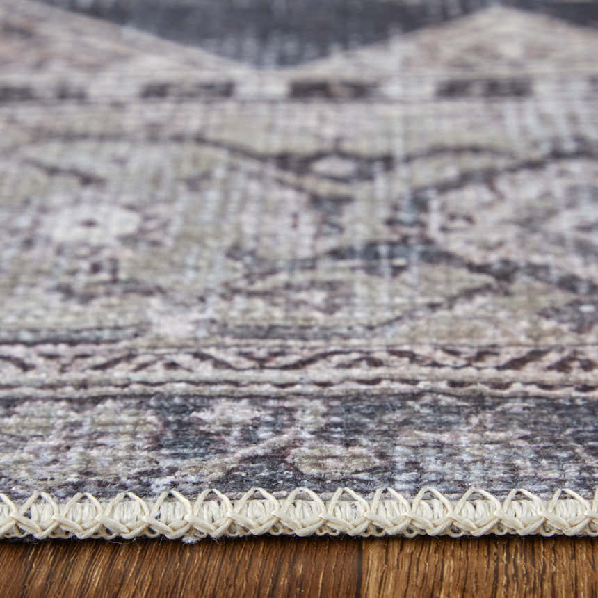 Close-up of Feizy Percy rug showing gray, ivory, and taupe medallion pattern and textured edge on wood floor. Pile