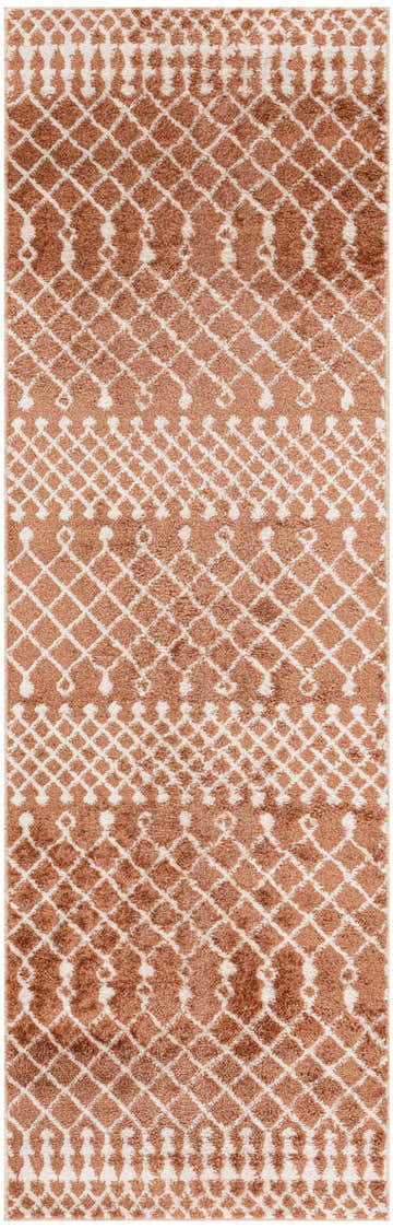 Close-up of the Nourison Astra rug. Copper-colored, with a geometric diamond and tassel pattern. Soft, textured pile.