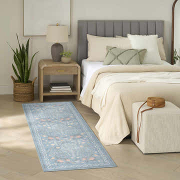 Bedroom scene with a light blue Nourison Botanical runner rug, wood floors, and neutral furniture.