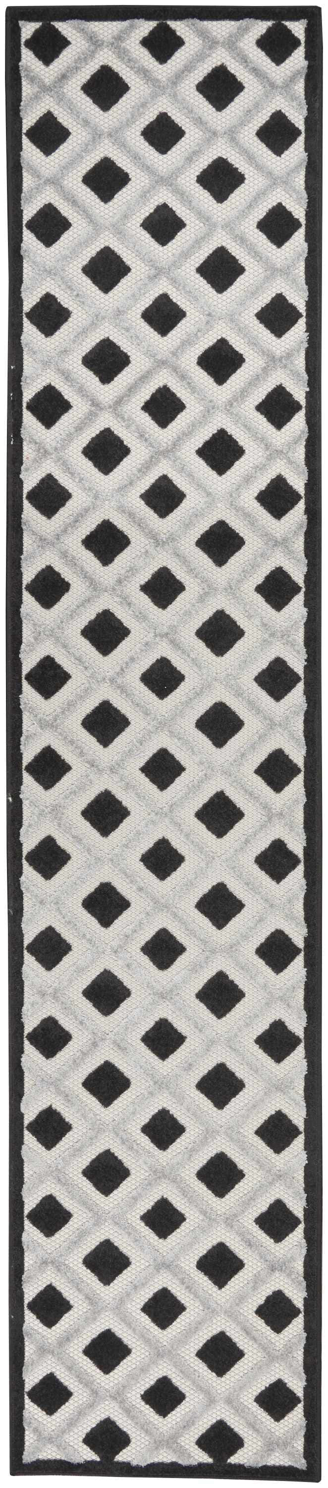 Close-up of Nourison Aloha Black White Modern Area Rug; black diamond pattern on a textured white background.