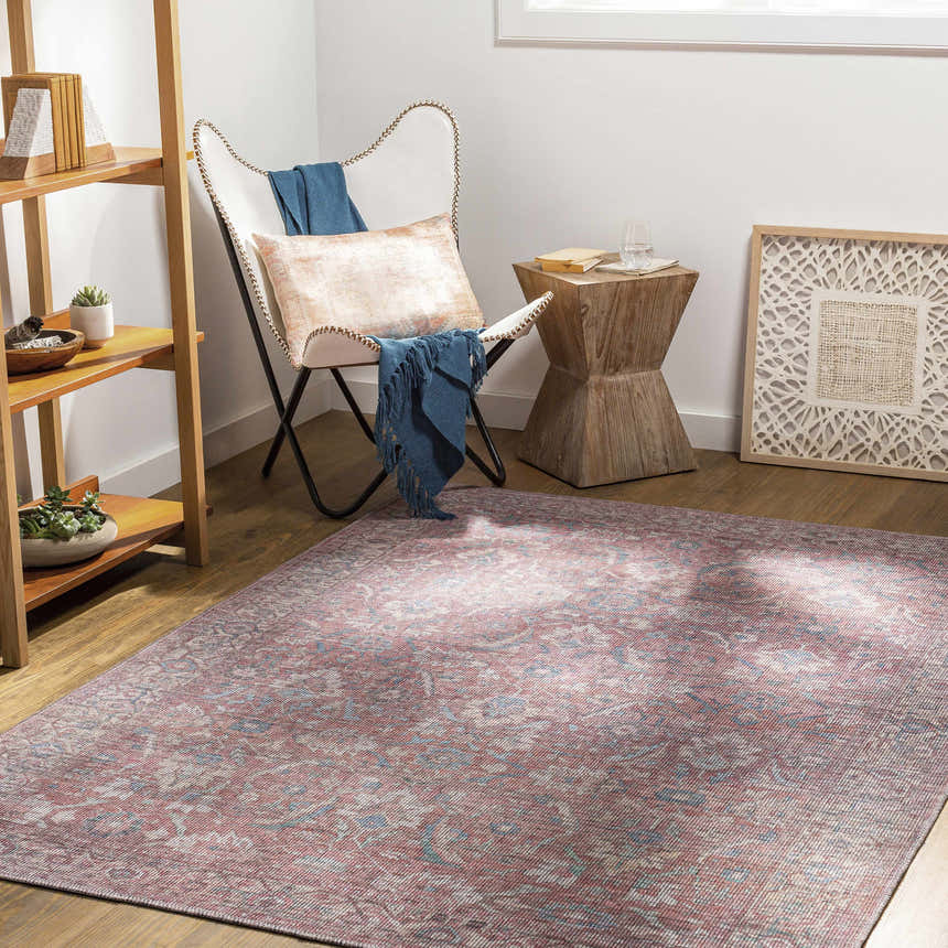 Living room scene with Amio Washable Printed Jute Rug in red and blue, butterfly chair, and wooden accents. Roomscene-Rectangle