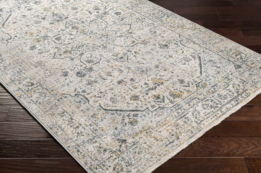 Close-up of Anmoore Luxe Rug. Cream rug with charcoal, gray, and mustard traditional Persian-style pattern. Corner
