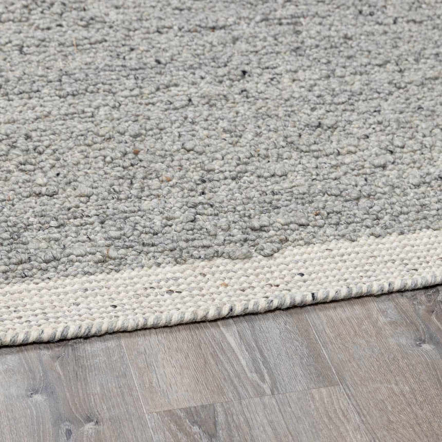 Close up of the hand woven Basiao Area Rug. Charcoal, cream, and gray wool and cotton texture. Pile