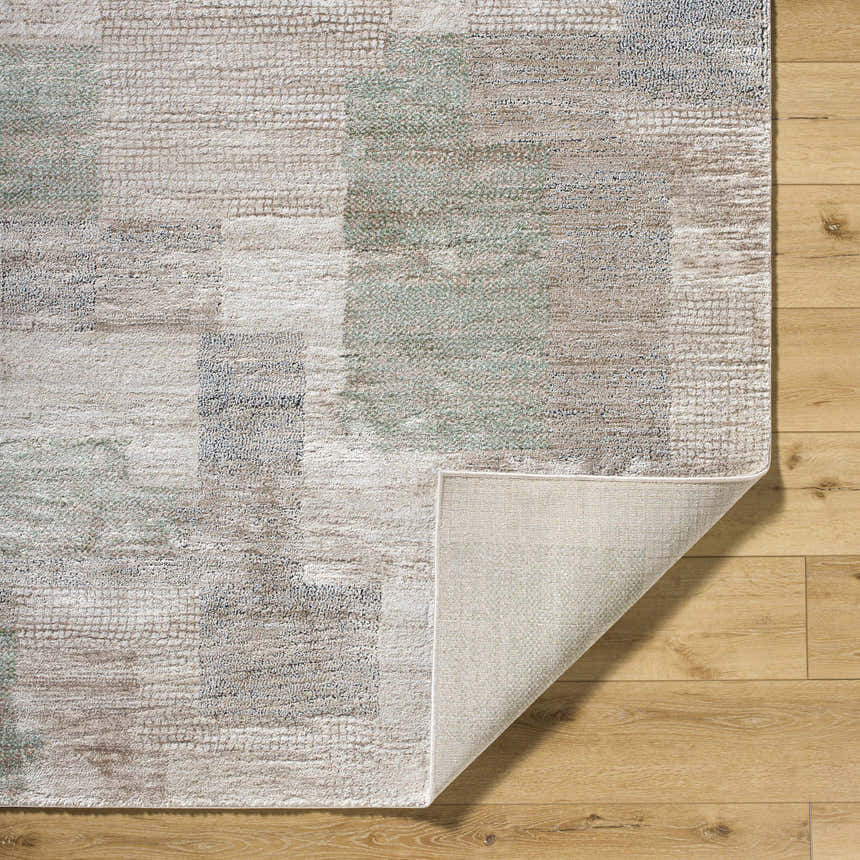 Close-up of the Anaisa Ivory Luxe Thick Area Rug showing its ivory, tan, sage, and gray contemporary block pattern. Fold