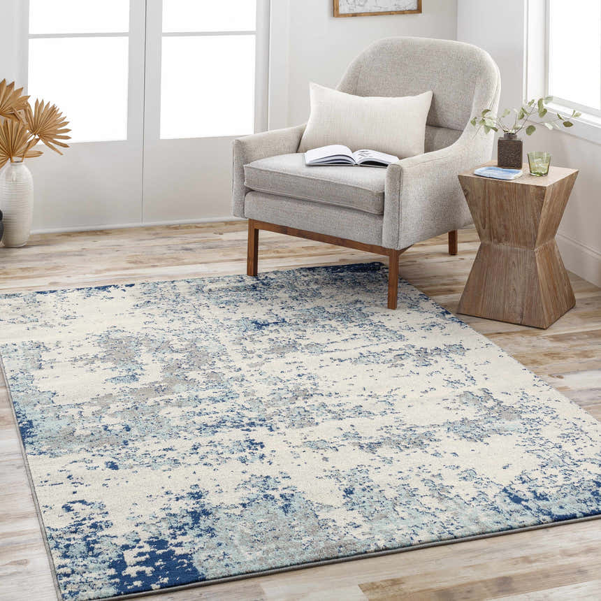 Living room scene with a Beverly Abstract Blue Area Rug, gray chair, and wood side table. Roomscene-Rectangle