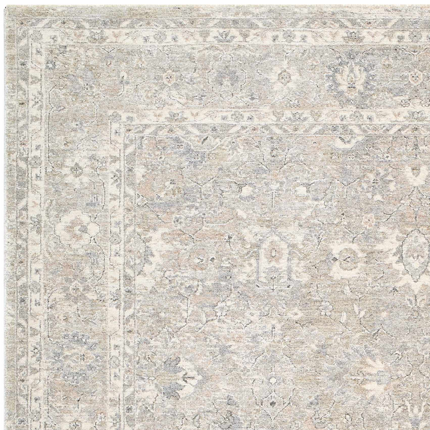 Close-up of the Banyan Luxe Area Rug, showcasing its ivory, pale blue, silver gray, and taupe farmhouse-style design. Corner
