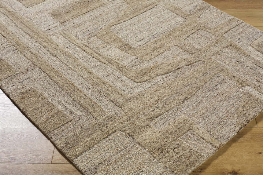 Close-up of the hand-tufted Brasen Tan Area Rug. Beige, tan, and taupe wool rug with a geometric pattern. Farmhouse style. Corner