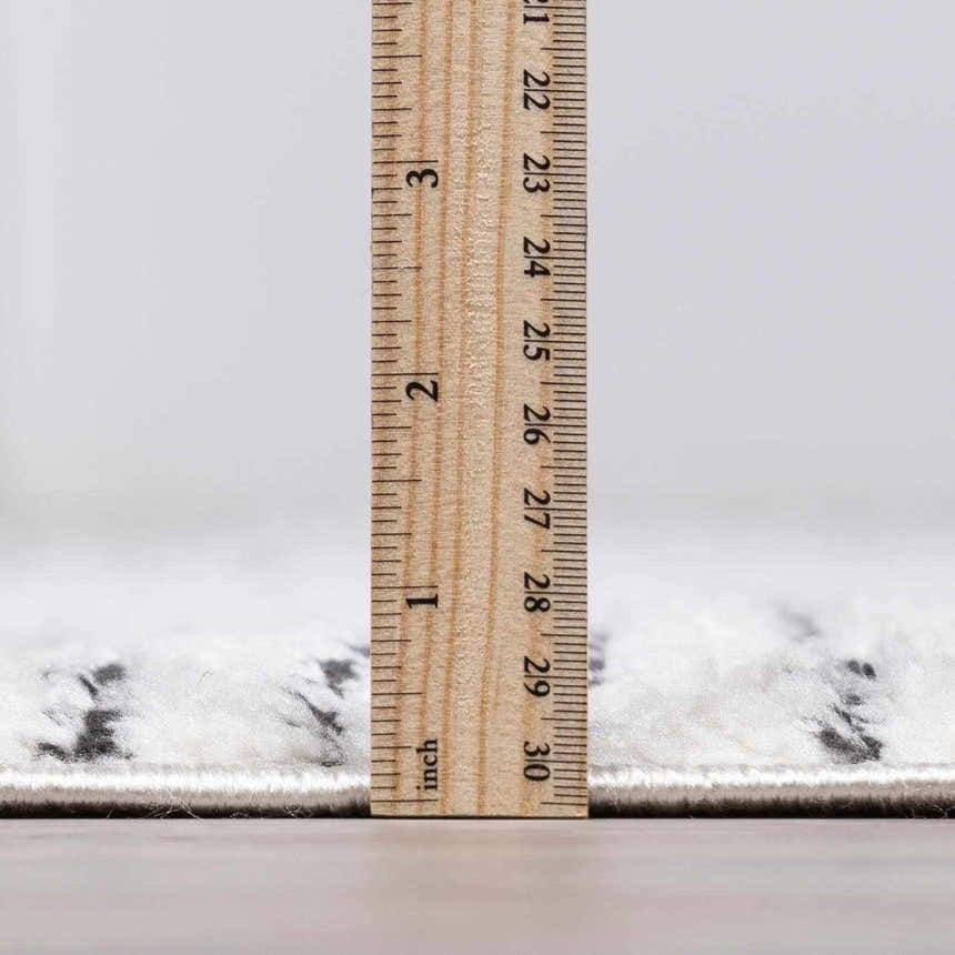 Close-up of the Modern Scandi Architect I Area Rug showing the high pile and thickness with a ruler. Pile