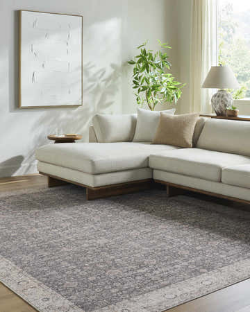 Living room scene with a charcoal and ivory Spokane PNW Home x LIVABLISS area rug under a modern sectional sofa. Roomscene-Rectangle