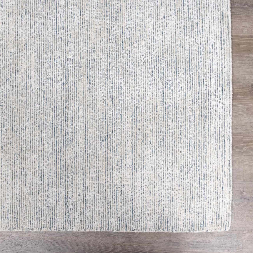 Close-up of the Orcas Hand Tufted Wool-Blend Rug in Slate, showing its striped texture and blue and cream colors. Swatch
