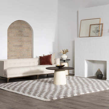 Living room scene with a Barbate Gray area rug, cream sofa, round coffee table, and decorative fireplace. Roomscene-Rectangle