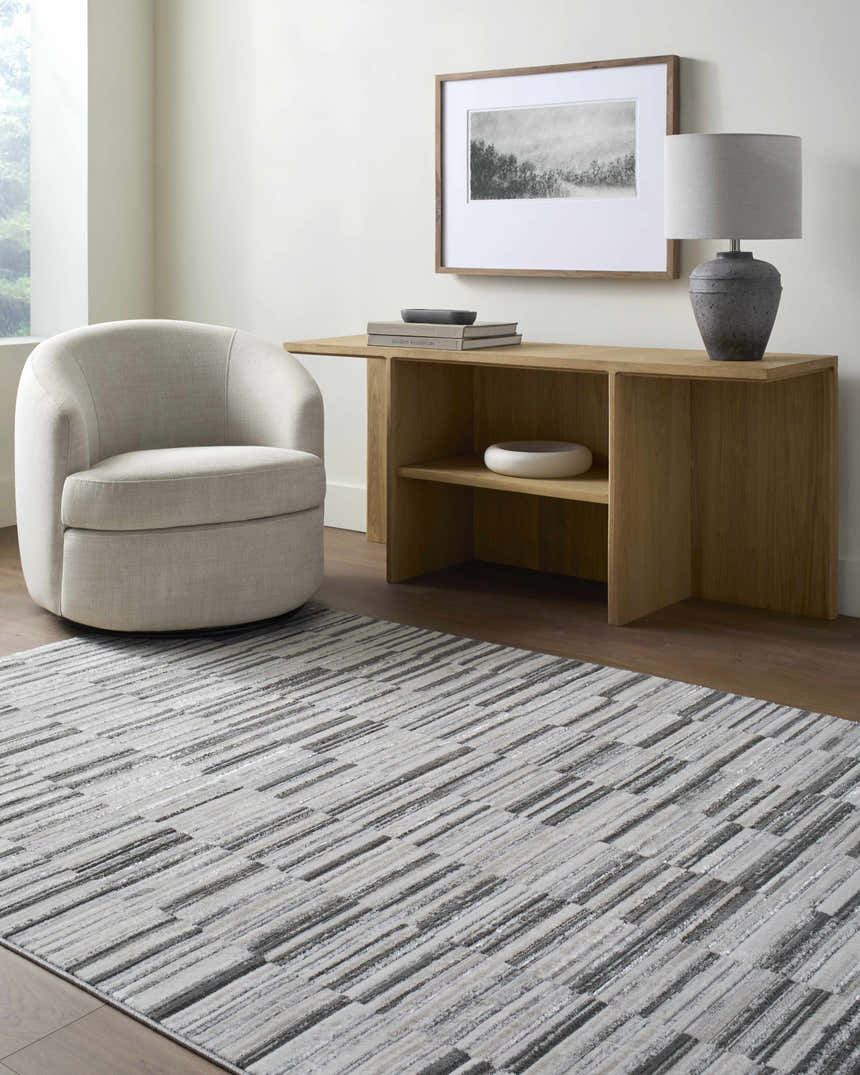 Living room scene with Bronco Broken Striped Area Rug, gray chair, and wood console table. Contemporary style. Roomscene-Rectangle