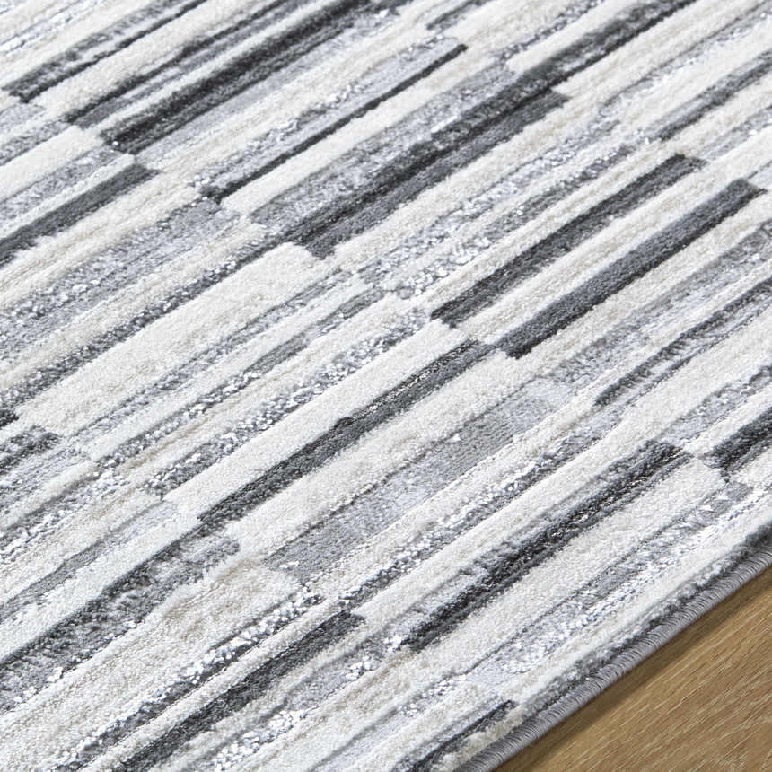 Close-up of Bronco Broken Striped Area Rug. Contemporary design with black, charcoal, gray, and ivory stripes. Texture