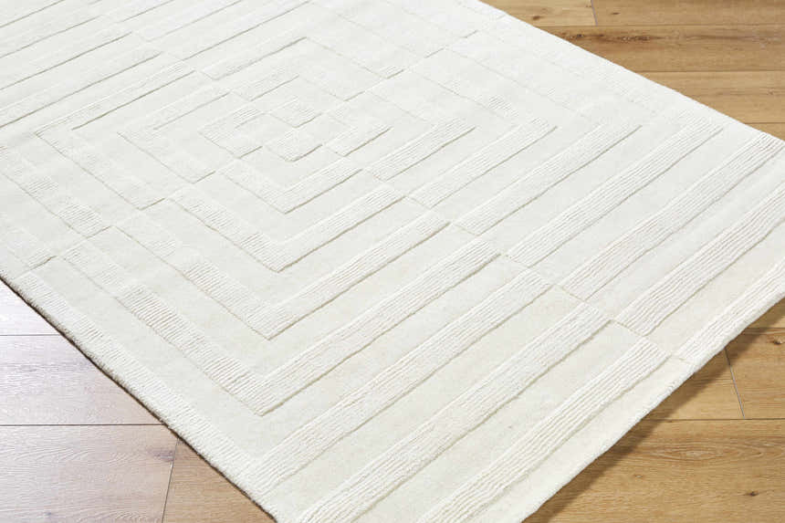Close-up of the cream Armina Area Rug featuring a contemporary geometric pattern and hand-loomed wool texture. Corner