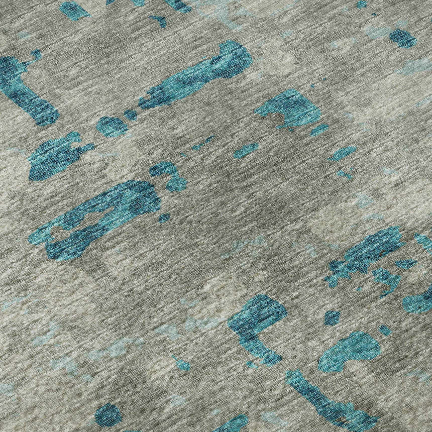 Close-up of Dalyn Brisbane BR5 Teal Washable Area Rug. Gray rug with abstract teal shapes and a textured, casual design.