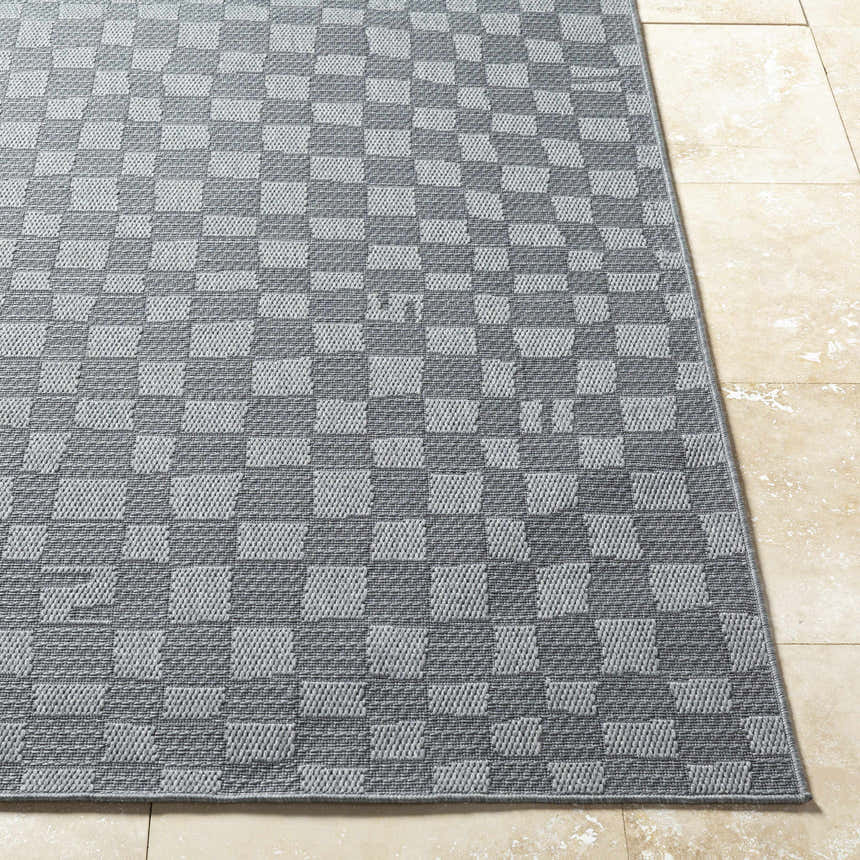 Close-up of the Arifah Gray Area Rug with a checkered pattern and textured weave on a tile floor. Front