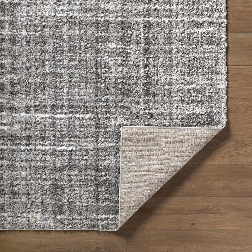 Close up of the Reyoa Light Gray rug showing the polyester texture and machine woven construction. Fold