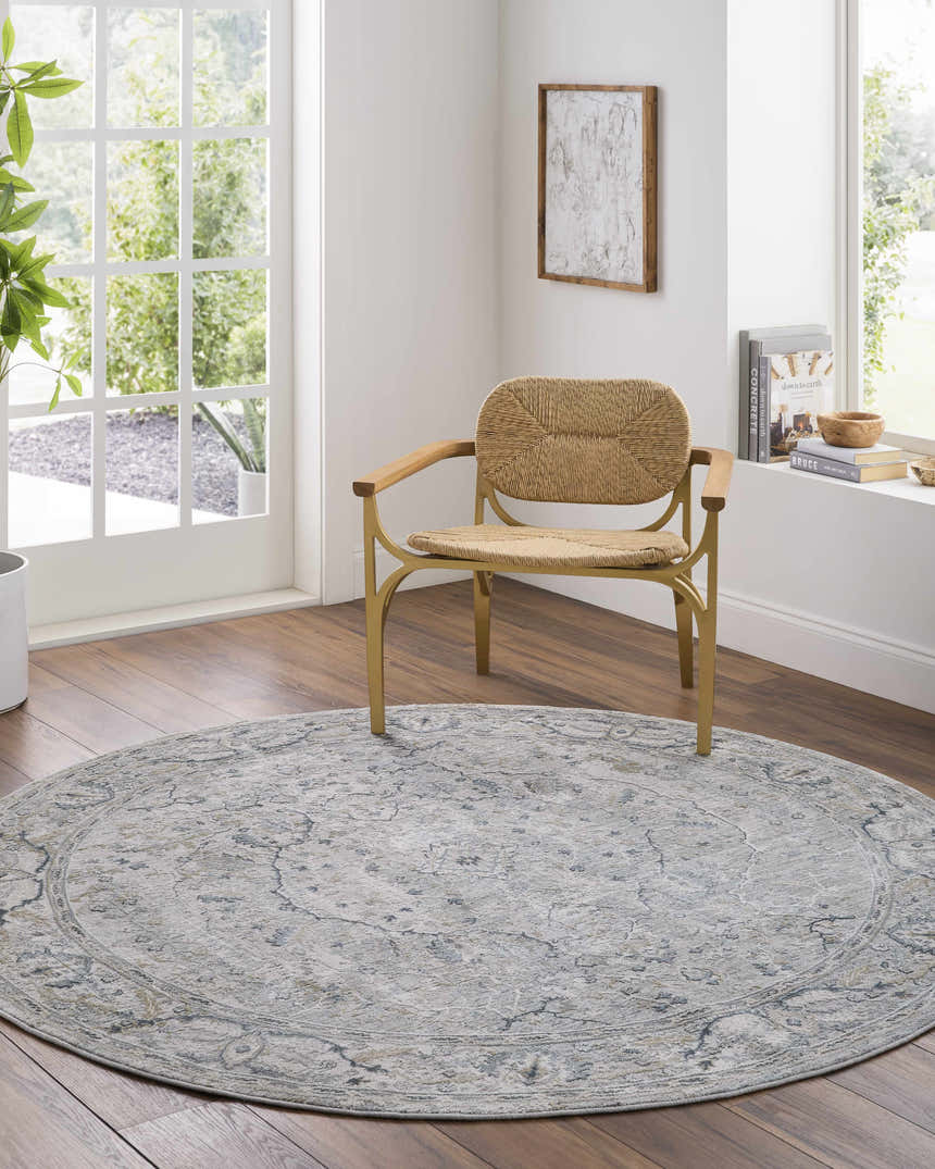 Light and airy room with a round, dusty sage Bushnell Thick Luxe Boutique Rug under a woven chair. Roomscene-Round