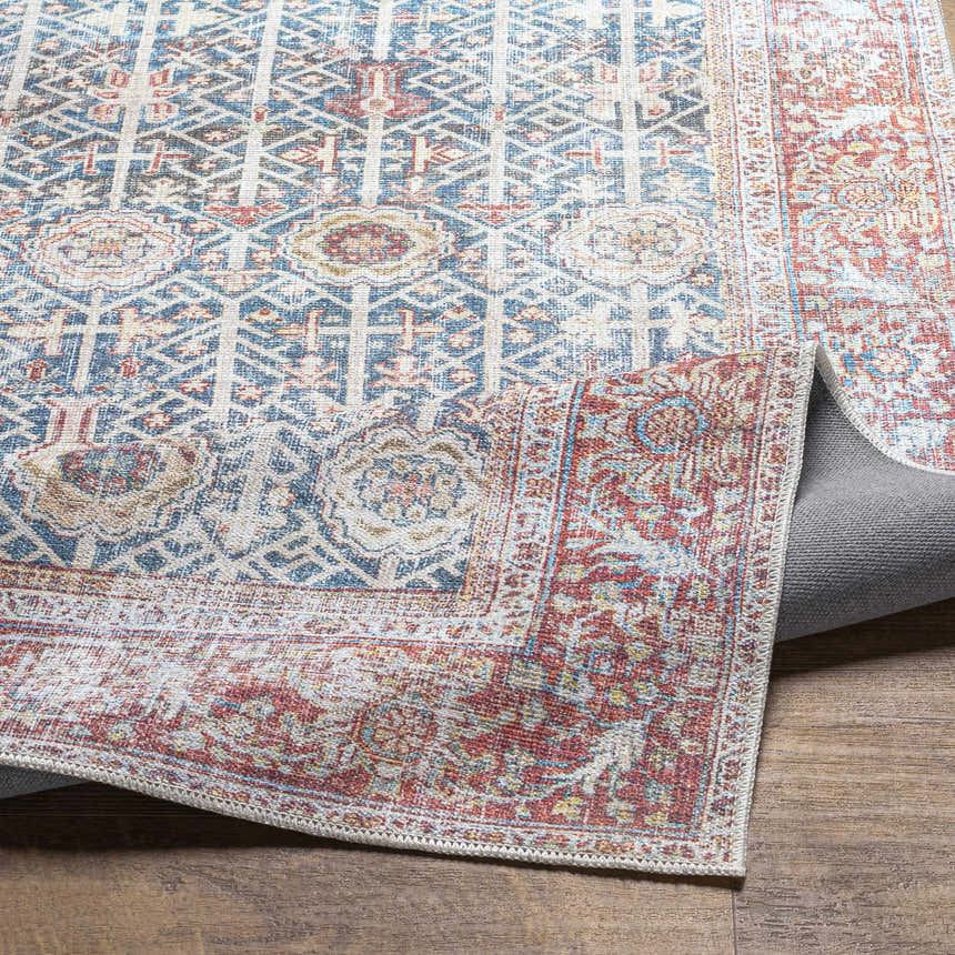 Close-up of the Rust Catadupa Distressed Washable Area Rug, showcasing its blue, gray, and rust Persian-style pattern and texture. Fold