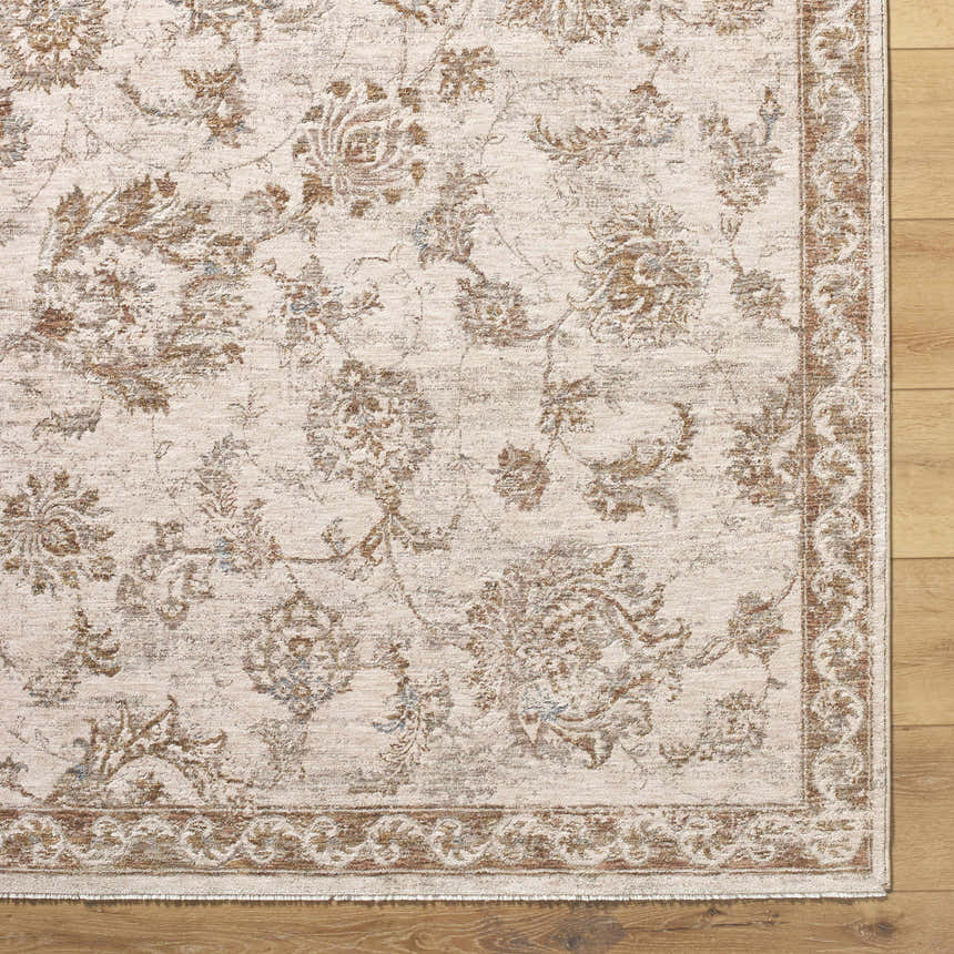Close-up of the Chyron Cream Area Rug showing its floral pattern, light brown accents, and traditional border on a wood floor. Corner