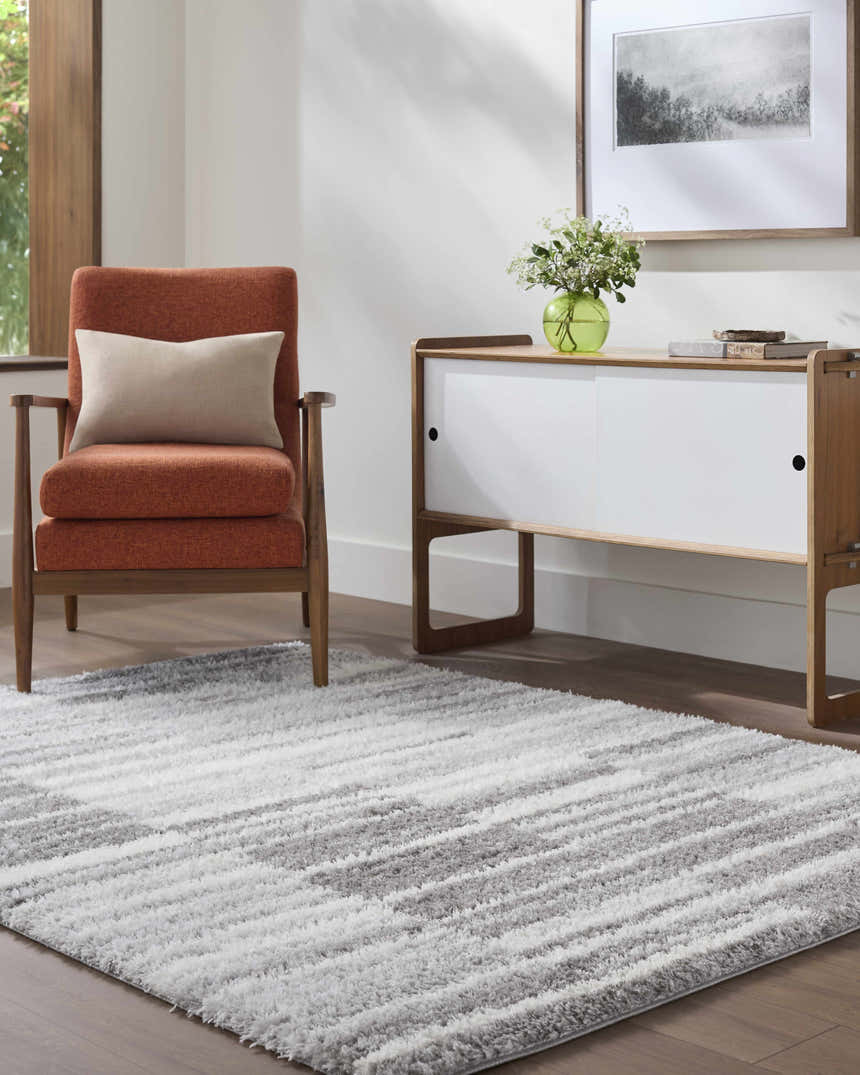 Living room scene with an orange chair and gray and ivory Carlen Gray Area Rug. Roomscene-Rectangle
