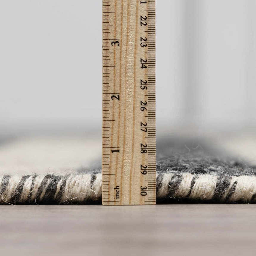 Close-up of the thick pile and construction of the Chilliwack Gray Plaid Wool Rug with ruler. Pile