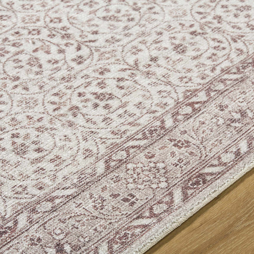 Close-up of the Spokane Machine Woven rug showing its burnt orange and cream traditional pattern and soft polyester texture. Texture