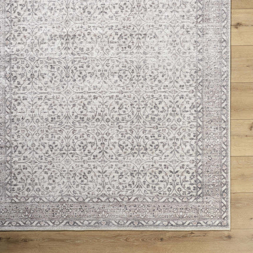 Close-up of the Spokane Cream Area Rug showing its traditional floral pattern and soft black, cream, and tan colors. Corner