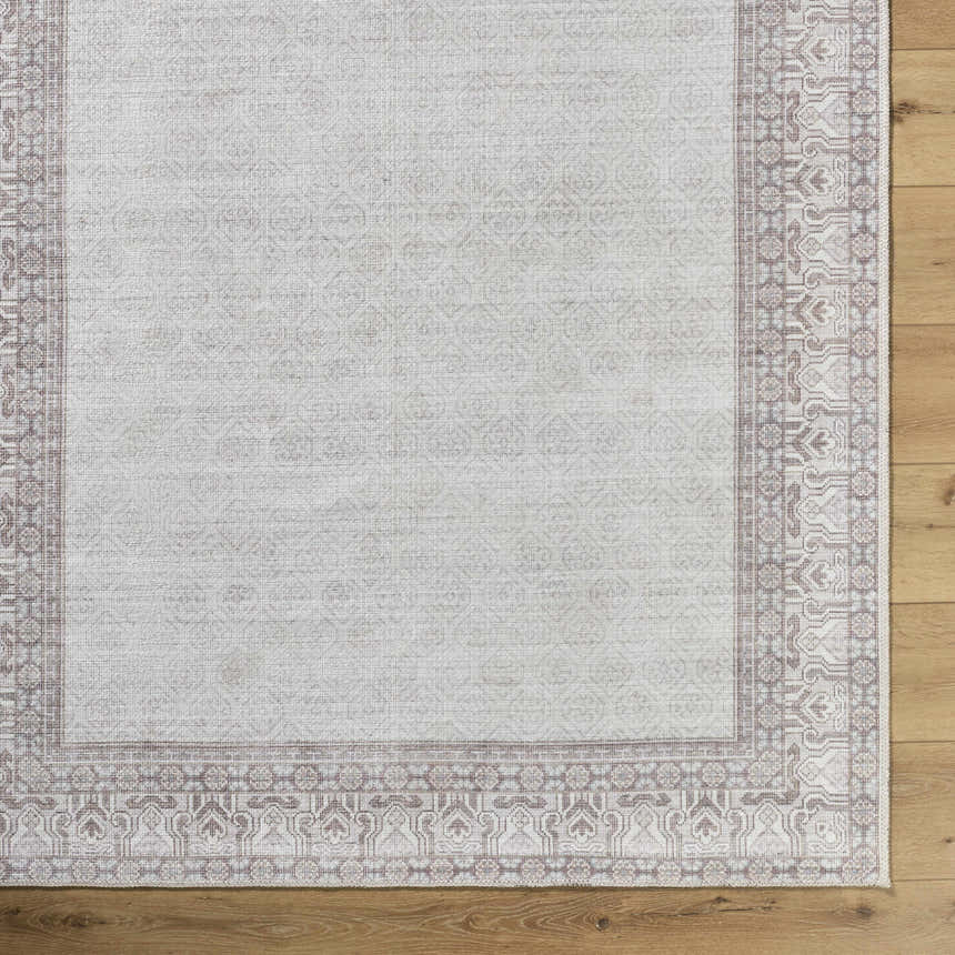 Close-up of the Rainier Cottage Border Brown Washable Rug showing its cream color and traditional brown border pattern. Swatch