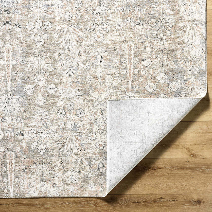 Close-up of the Carlyn Area Rug showing its cream, sage, and slate floral pattern and soft texture on wood floors. Fold