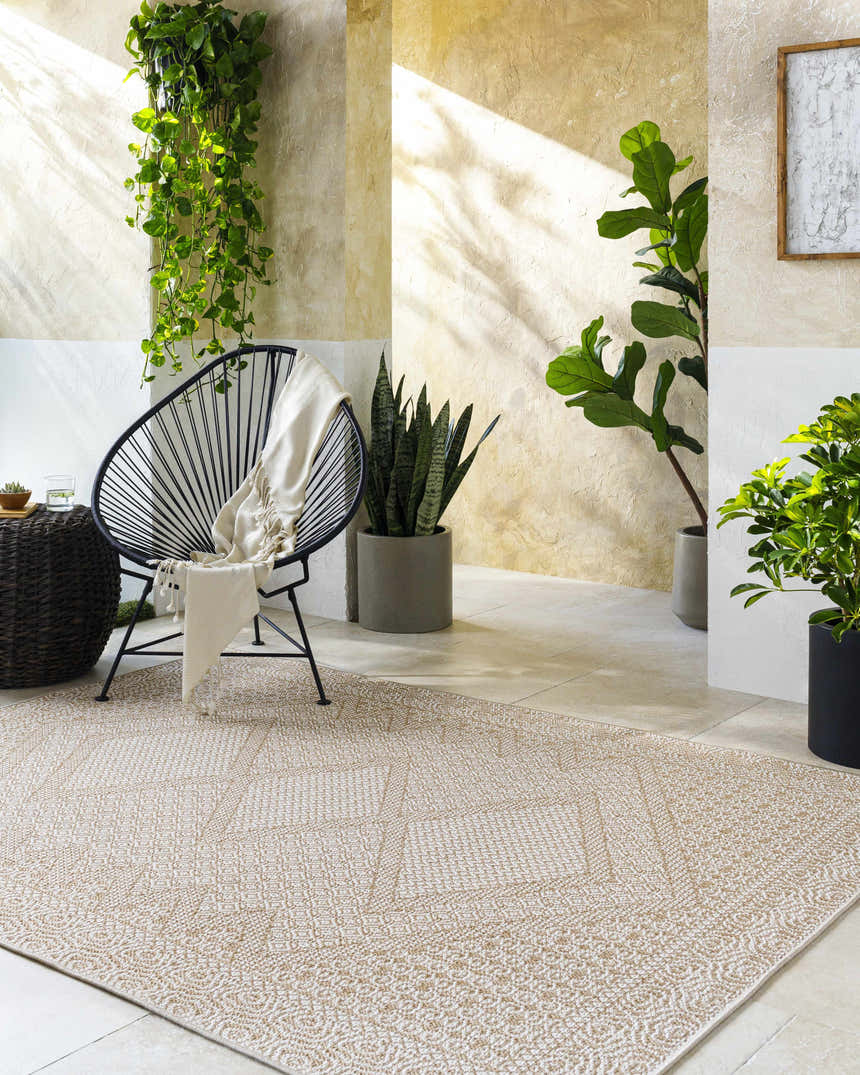 Sunlit room scene with a tan and white Chaman Area Rug, modern chair, and potted plants creating a serene, transitional space. Roomscene-Rectangle