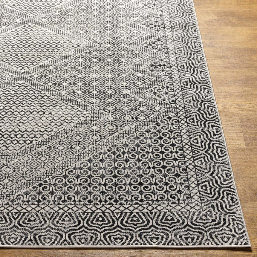 Close-up of the Coledale Black & White Washable Rug. Features a geometric, oriental-inspired pattern in black, gray, and light gray. Front