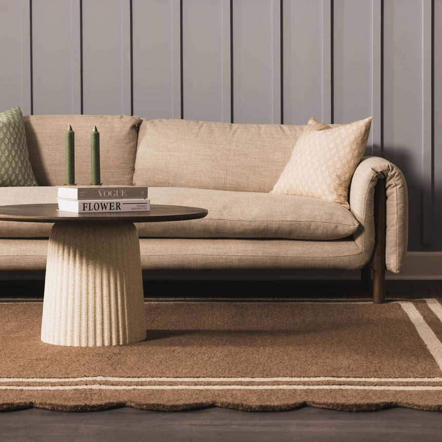 Living room scene with a Chogan Chocolate Brown Area Rug, beige sofa, and round coffee table. Roomscene-Rectangle