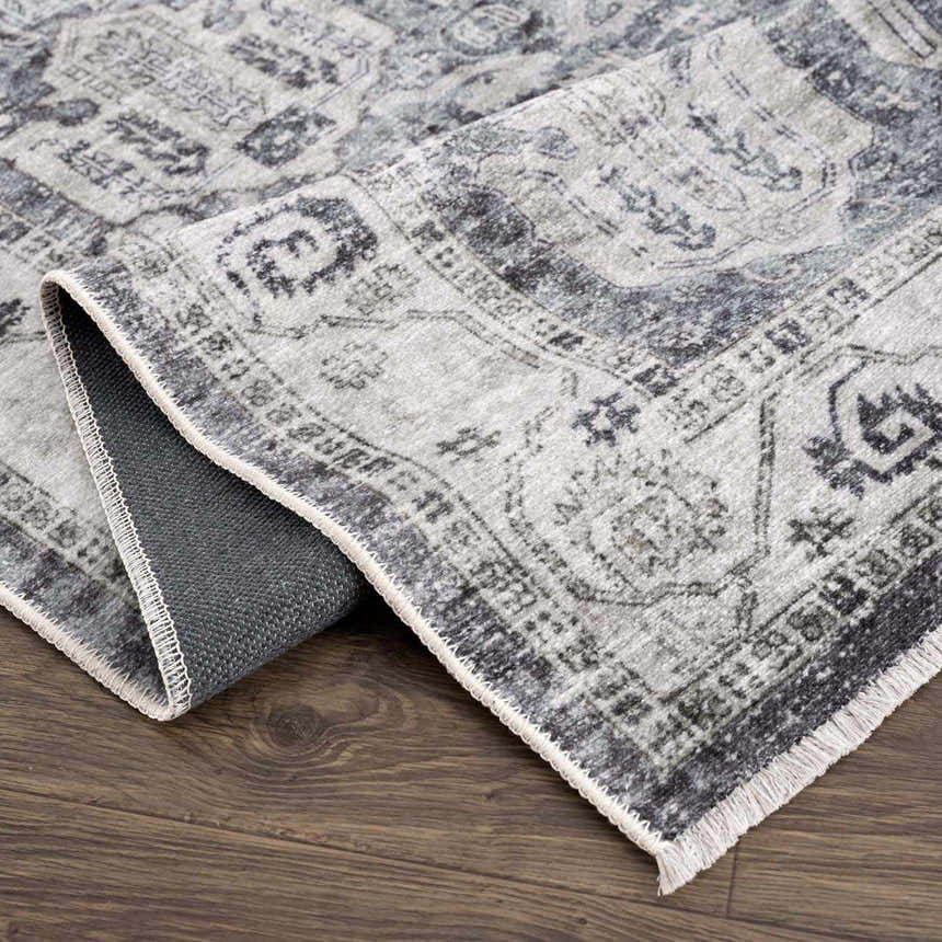 Close-up of the Off White Holi-4602 Washable Area Rug showing its traditional beige, charcoal, and gray vintage pattern. Fold