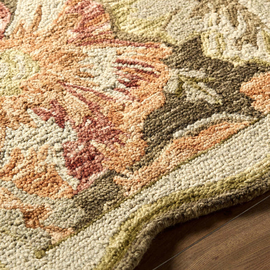 Close up of the hand-tufted Campos Area Rug. Wool rug with floral design in shades of cream, green, brown, and rust. Texture