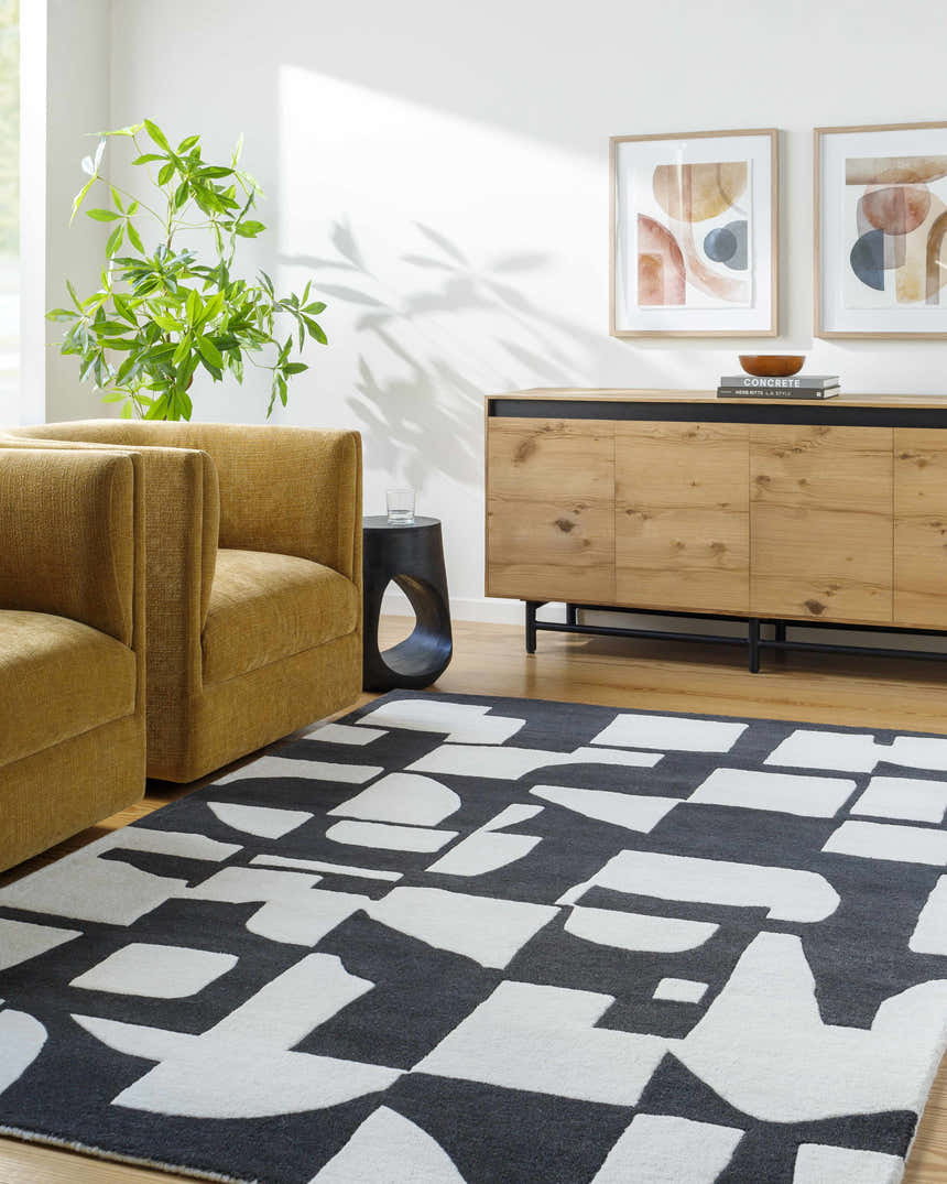 Living room scene with a Celous Area Rug, ivory and jet black geometric pattern, mustard chairs, and wood cabinet. Roomscene-Rectangle