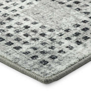 Close-up of the Delano DA1 Pewter area rug. Gray rug with a small, repeating geometric pattern and a textured gray border.