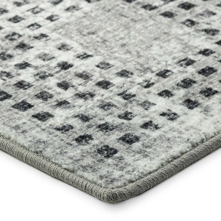 Close-up of the Delano DA1 Pewter area rug. Gray rug with a small, repeating geometric pattern and a textured gray border.