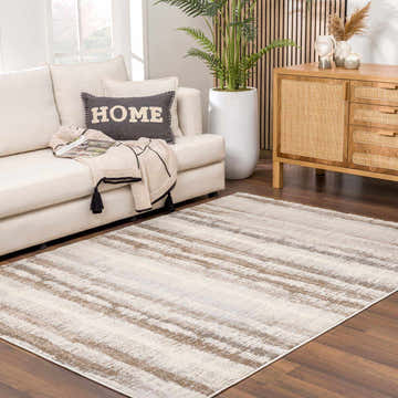 Living room scene with a neutral sofa and the Asmara Brown Area Rug on a wood floor. Roomscene-Rectangle