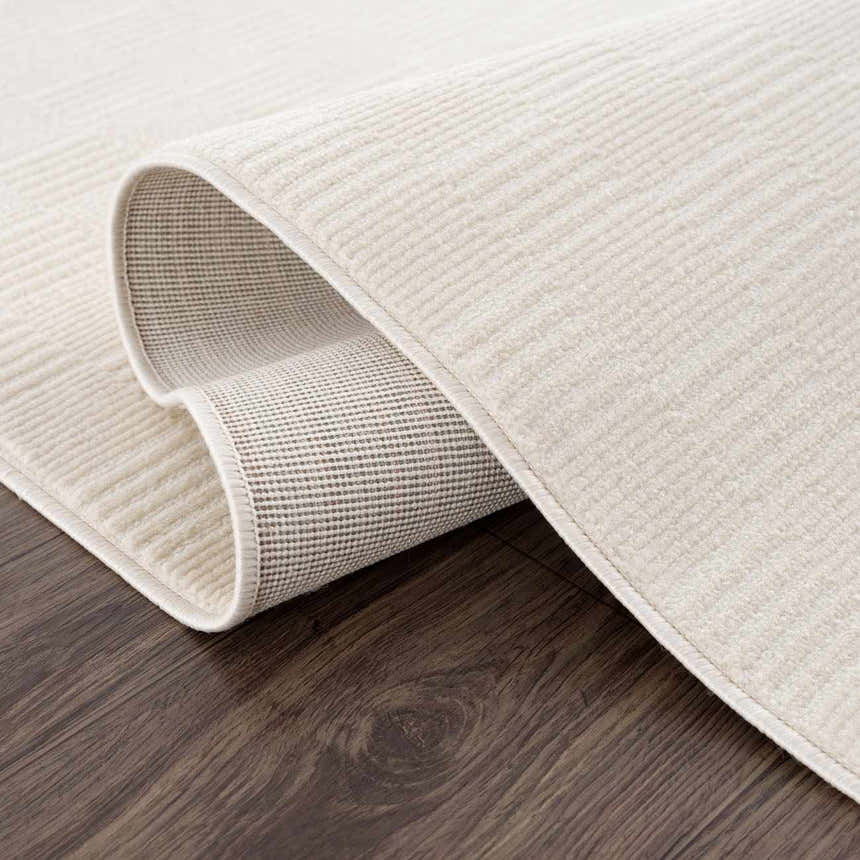 Close-up of the cream Kazuma Washable Area Rug showing its subtle checkered pattern and durable backing. Fold