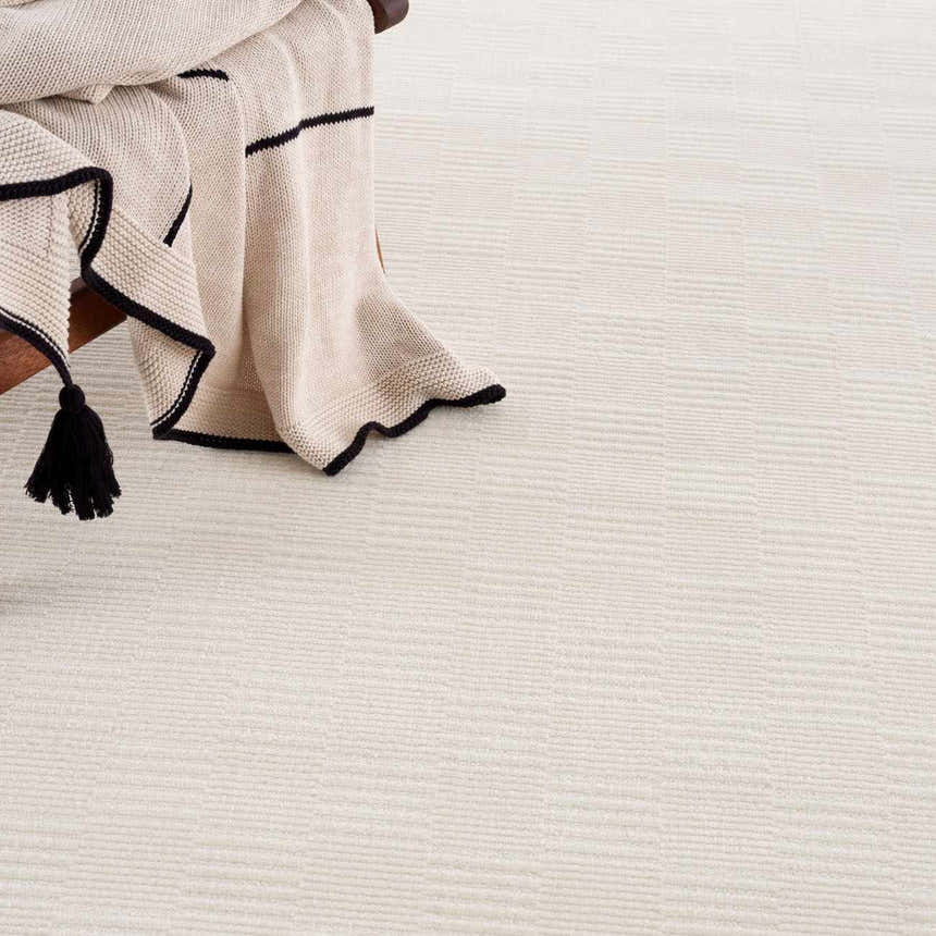 Close-up of the cream Kazuma Checkered Washable Area Rug showing its subtle checkered design and soft texture. Styleshot
