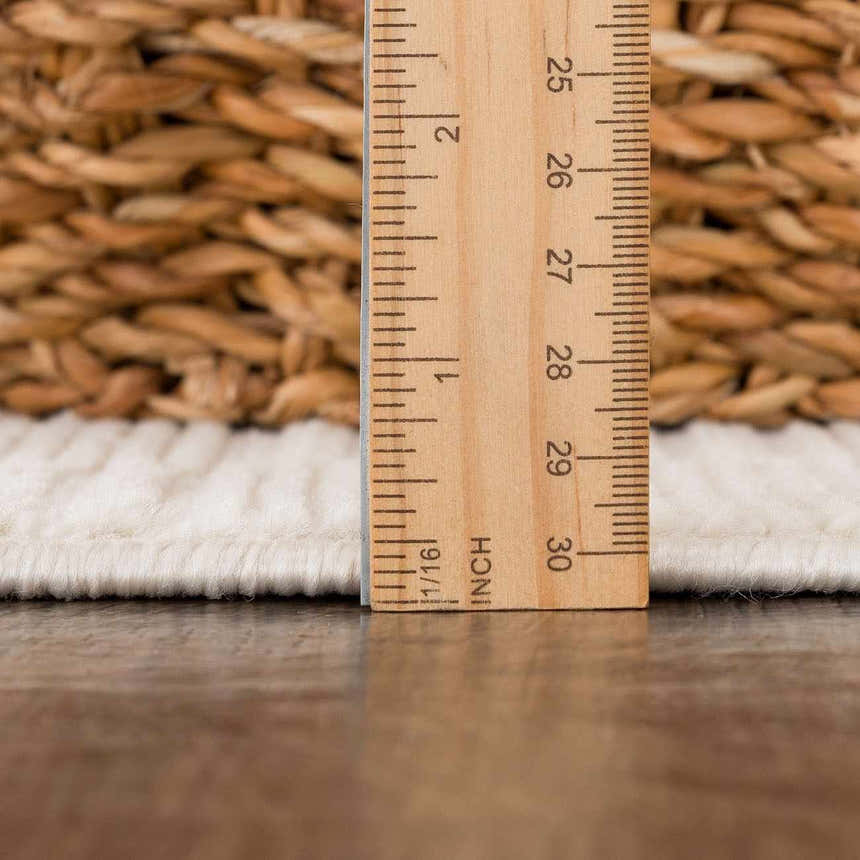 Close-up of the Kazuma Cream Checkered Washable Area Rug showing the pile height with a ruler. Cream and off-white tones. Pile